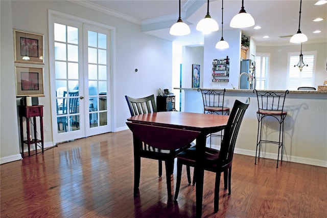 dining area with crown molding, dark hardwood / wood-style flooring, and plenty of natural light