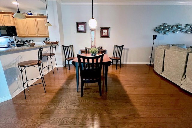 dining space with crown molding and dark wood-type flooring