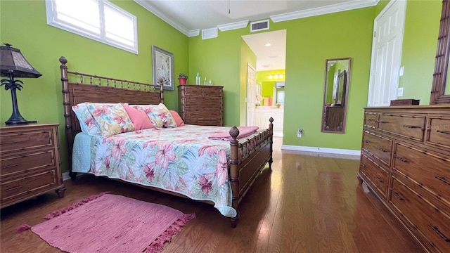 bedroom with connected bathroom, dark hardwood / wood-style flooring, and ornamental molding