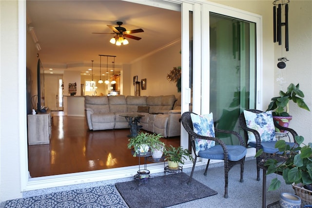 living room with ceiling fan and ornamental molding