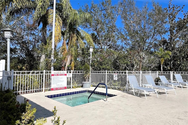 view of swimming pool featuring a hot tub