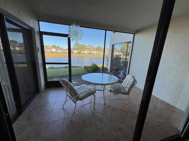 sunroom / solarium featuring a water view