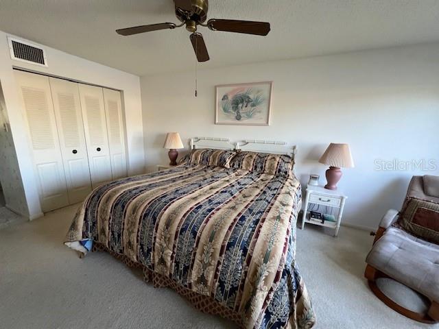 bedroom with carpet, ceiling fan, and a closet