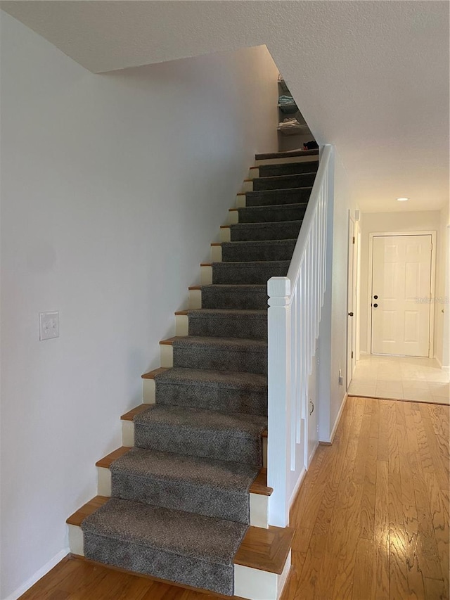 stairs featuring hardwood / wood-style floors