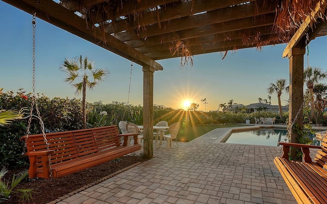 patio terrace at dusk featuring a pergola