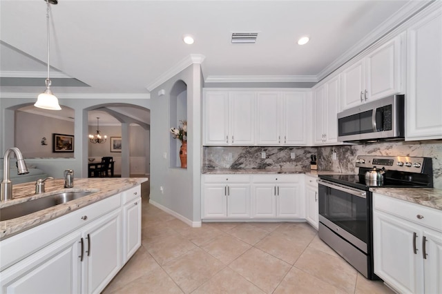 kitchen with appliances with stainless steel finishes, backsplash, white cabinetry, and pendant lighting