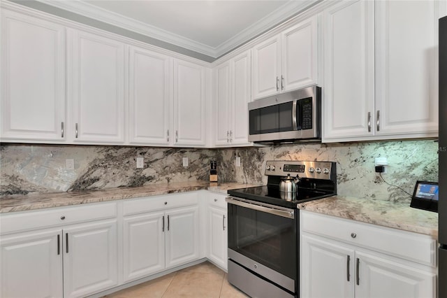 kitchen featuring appliances with stainless steel finishes, backsplash, ornamental molding, light tile patterned floors, and white cabinetry