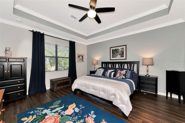 bedroom with ceiling fan, dark hardwood / wood-style floors, ornamental molding, and a tray ceiling