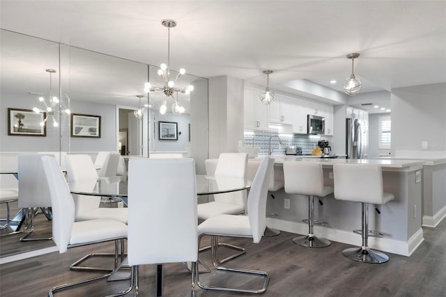 dining space with dark hardwood / wood-style flooring and a chandelier