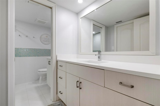 bathroom featuring toilet, vanity, and tile patterned floors