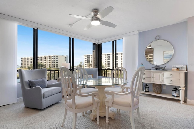 carpeted dining room featuring ceiling fan, plenty of natural light, and expansive windows