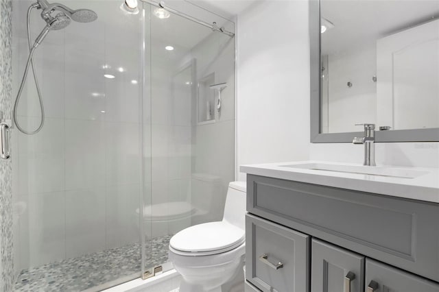 bathroom with an enclosed shower, vanity, and toilet