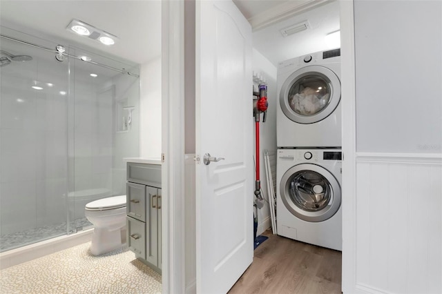 washroom featuring stacked washer and clothes dryer and hardwood / wood-style flooring