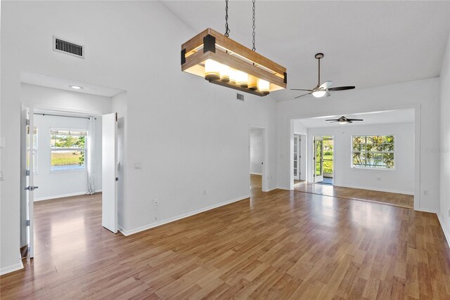 unfurnished room with ceiling fan, plenty of natural light, wood-type flooring, and lofted ceiling