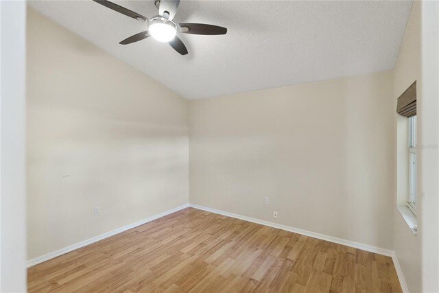 empty room featuring a textured ceiling, ceiling fan, light hardwood / wood-style floors, and vaulted ceiling