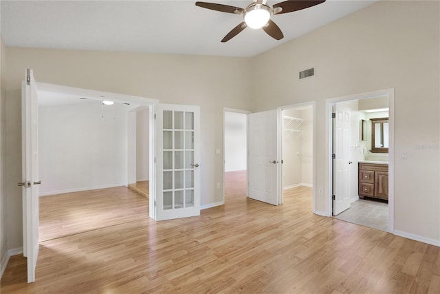 empty room featuring ceiling fan, high vaulted ceiling, and light hardwood / wood-style floors