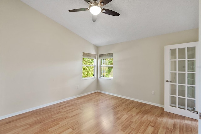 spare room featuring a textured ceiling, light hardwood / wood-style flooring, ceiling fan, and lofted ceiling