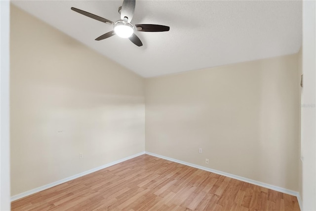 empty room with a textured ceiling, ceiling fan, light hardwood / wood-style flooring, and vaulted ceiling