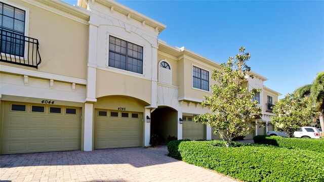 4046 Overture Cir Unit 4046, Bradenton, FL 34209 - view of property featuring an attached garage, stucco siding, and decorative driveway