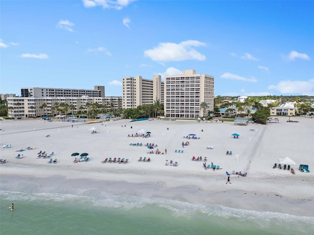 birds eye view of property with a water view and a beach view