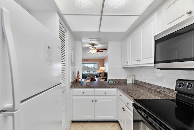 kitchen featuring electric range, white refrigerator, white cabinets, and light tile patterned floors