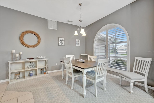 carpeted dining area featuring a chandelier