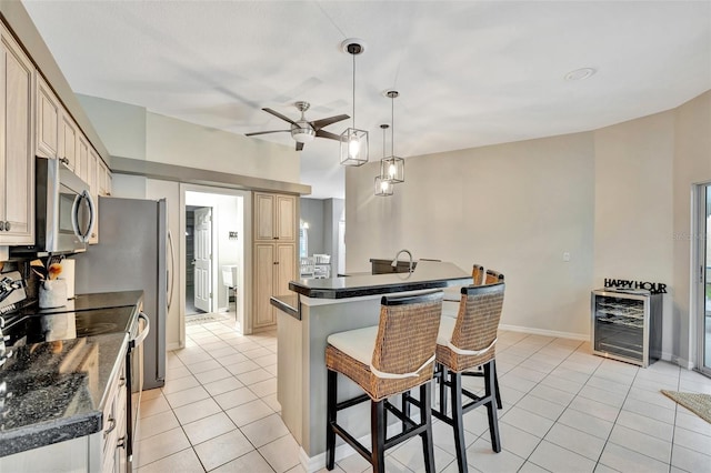 kitchen with pendant lighting, wine cooler, ceiling fan, range with electric stovetop, and a breakfast bar area