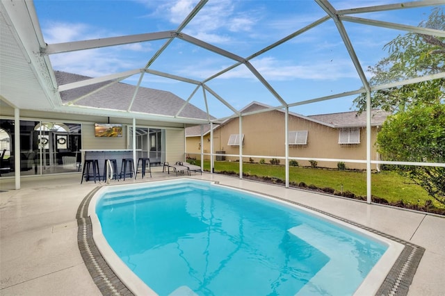 view of swimming pool with a lanai, ceiling fan, exterior bar, and a patio