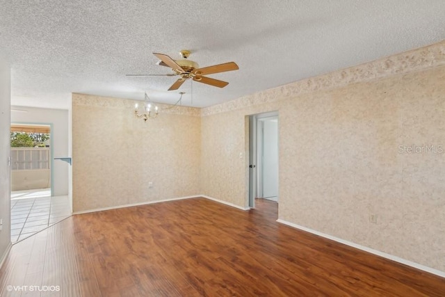 unfurnished room with hardwood / wood-style floors, ceiling fan with notable chandelier, and a textured ceiling