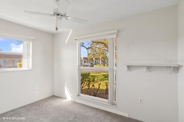 spare room featuring ceiling fan, carpet floors, and a textured ceiling