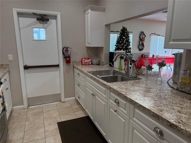 kitchen with white cabinetry, sink, and light tile patterned floors