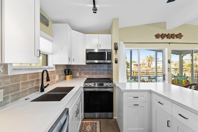 kitchen with white cabinetry, sink, vaulted ceiling, and appliances with stainless steel finishes