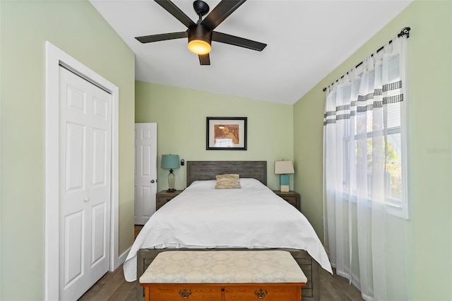 bedroom featuring ceiling fan, dark hardwood / wood-style floors, lofted ceiling, and a closet