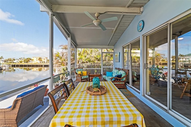 unfurnished sunroom with vaulted ceiling with beams, ceiling fan, and a water view