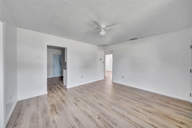 unfurnished room with ceiling fan, a textured ceiling, and light wood-type flooring