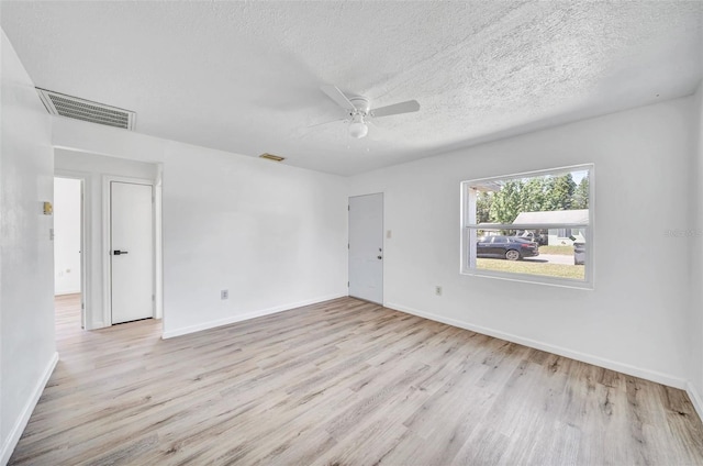 spare room with ceiling fan, light hardwood / wood-style floors, and a textured ceiling