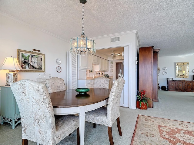 dining area with light carpet, a textured ceiling, a chandelier, and ornamental molding