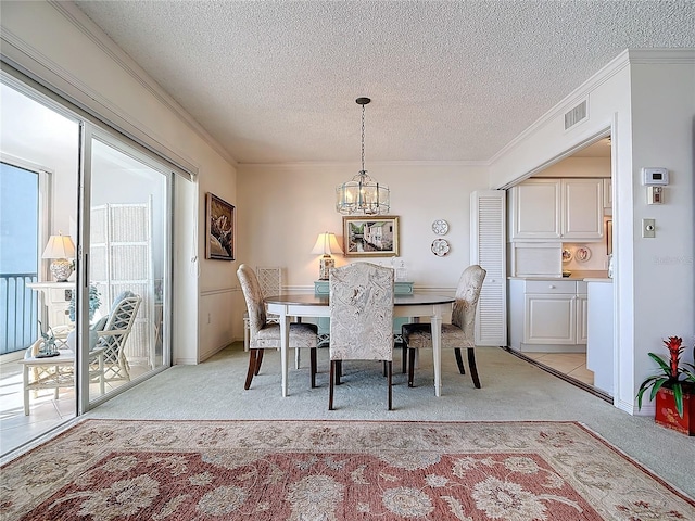 dining room with light carpet, a textured ceiling, crown molding, and a notable chandelier