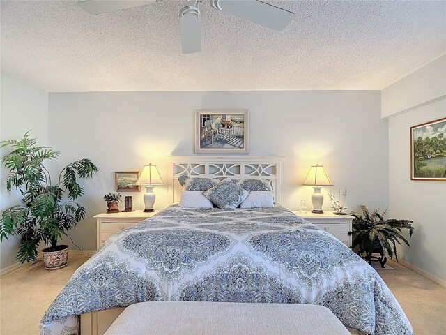 carpeted bedroom with ceiling fan and a textured ceiling