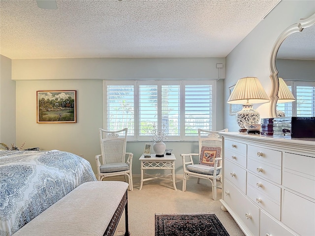 bedroom with multiple windows, light carpet, and a textured ceiling