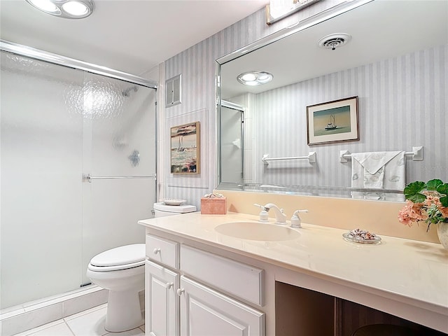 bathroom with tile patterned flooring, vanity, toilet, and walk in shower