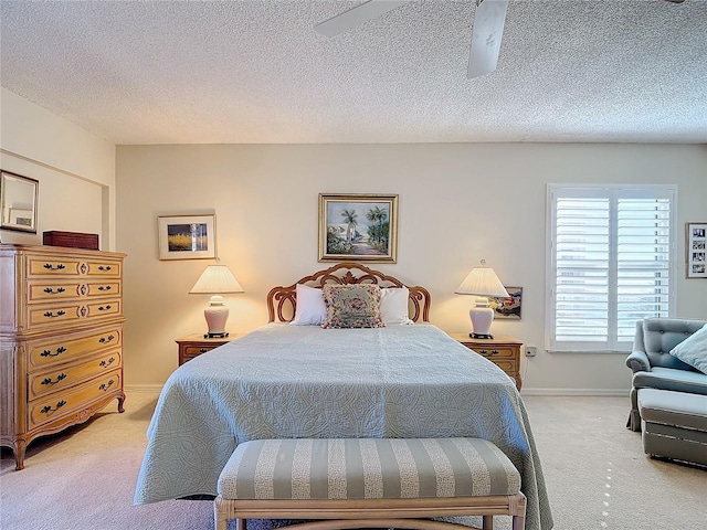 bedroom with ceiling fan, a textured ceiling, and light carpet