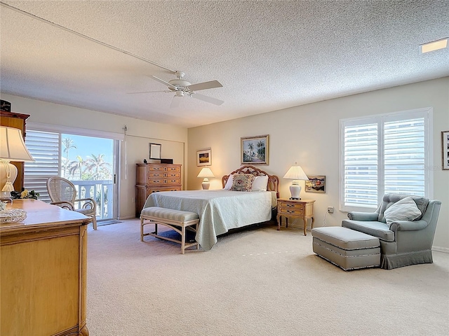 bedroom with multiple windows, ceiling fan, carpet, and a textured ceiling