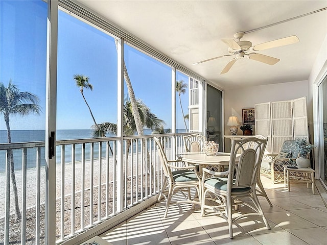 sunroom / solarium featuring a beach view, a water view, and ceiling fan