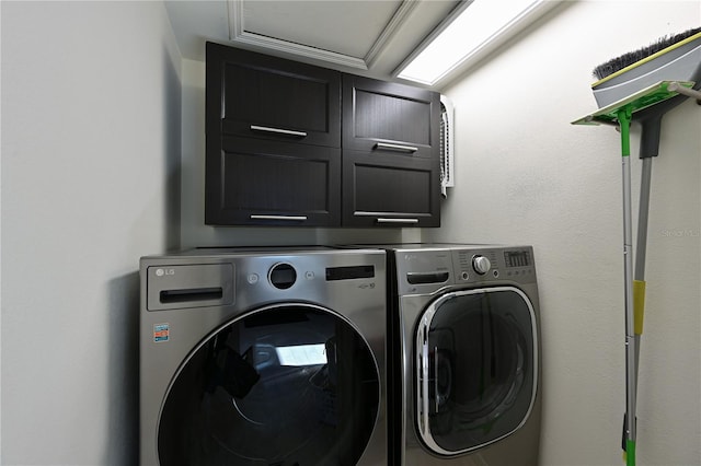 clothes washing area featuring cabinets and independent washer and dryer