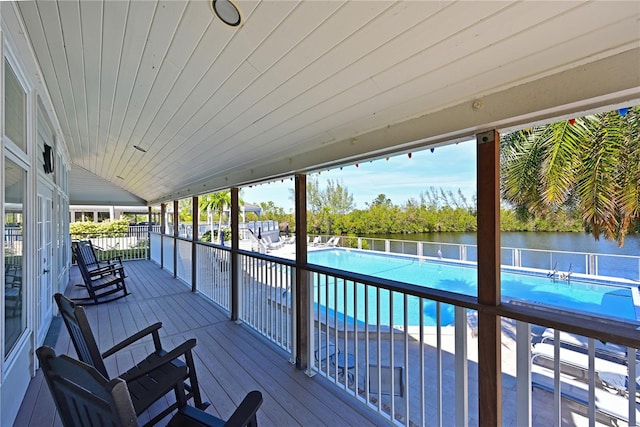 wooden terrace with a water view and a community pool