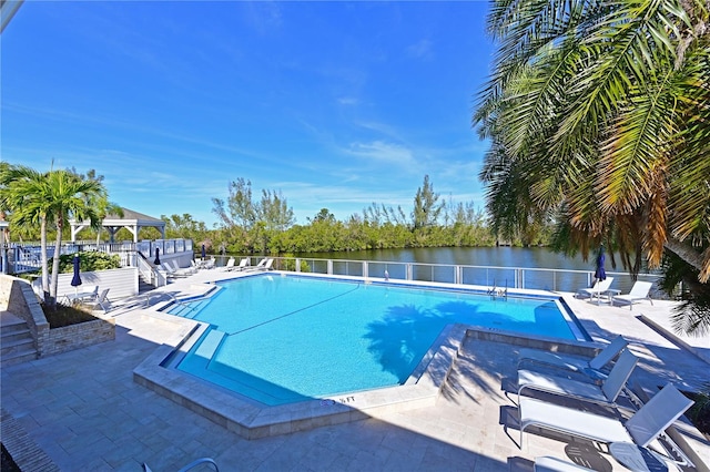 view of pool with a water view and a patio