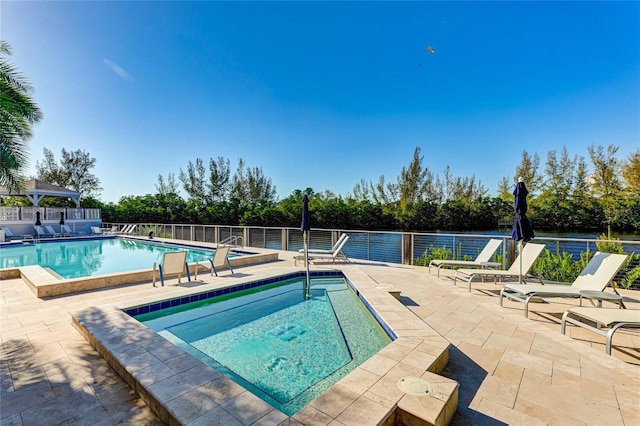 view of swimming pool with a hot tub and a patio area