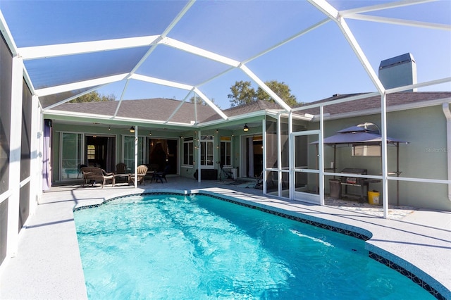 view of pool featuring ceiling fan, a lanai, and a patio area