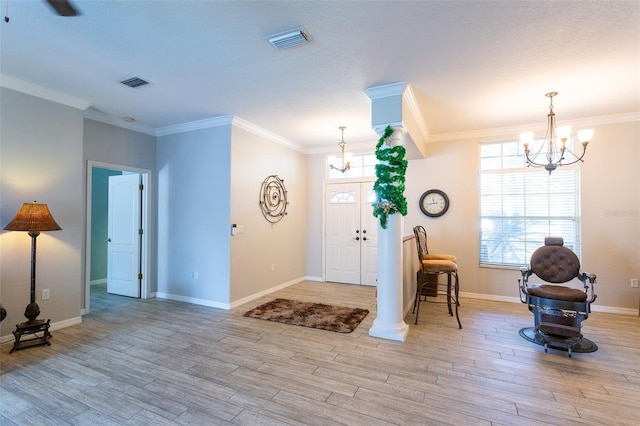 entryway featuring light hardwood / wood-style flooring, a chandelier, and ornamental molding